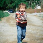 little boy running along smiling