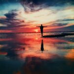 sunset-with-man-outstretched-arms-on-water-